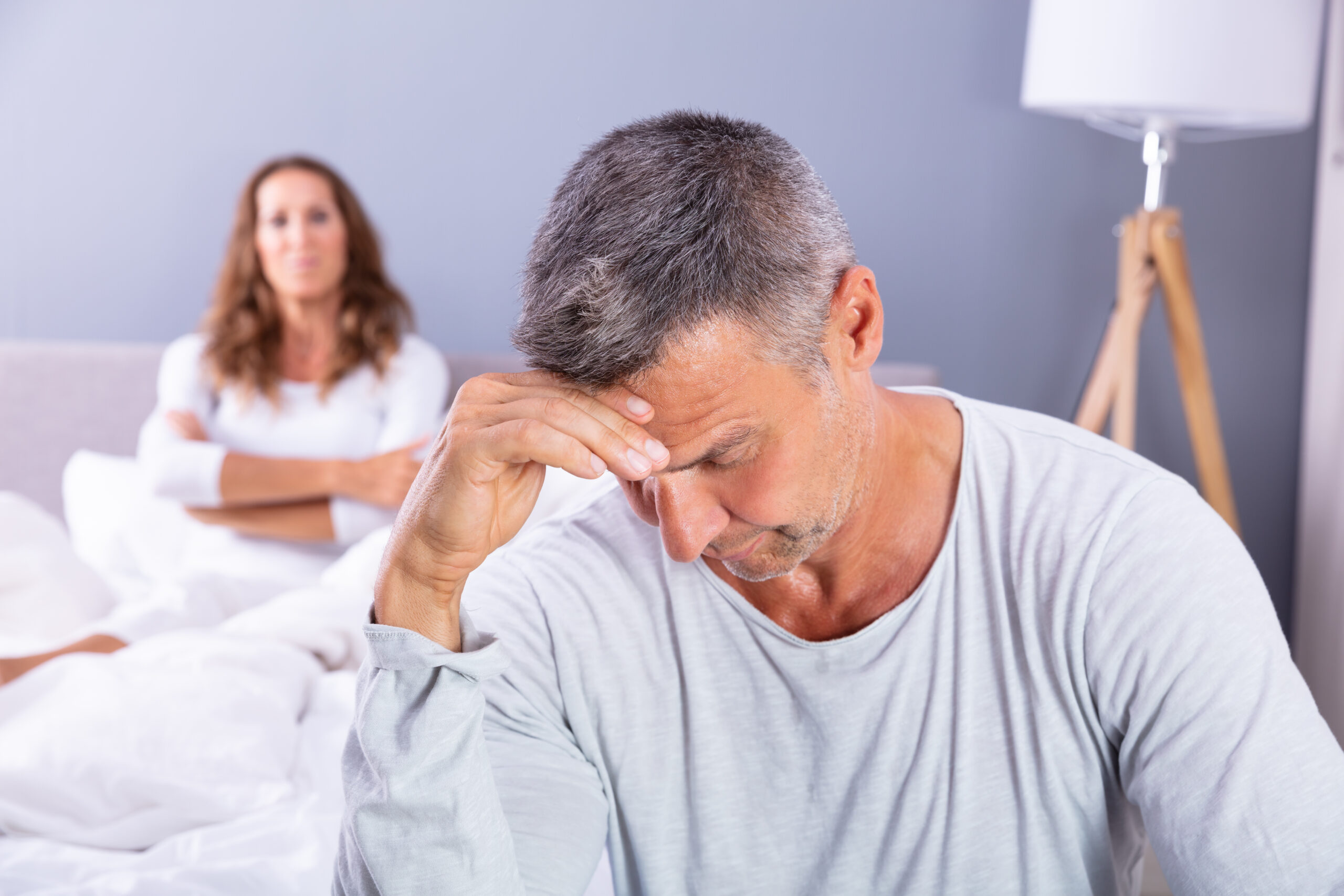 Close-up,Of,Depressed,Man,Sitting,On,Bed,In,Front,Of